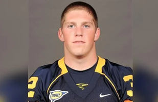 Image of a young man wearing a blue and gold football shirt.