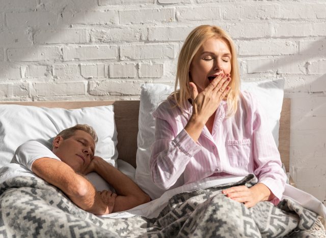 tired mature woman yawning in bed, concept of habits destroying weight loss progress