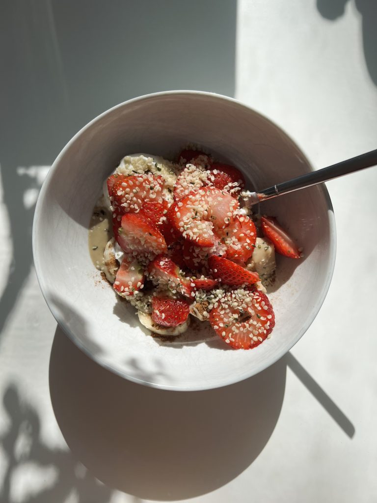 Bowl of sliced strawberries, yogurt and hemp seeds.