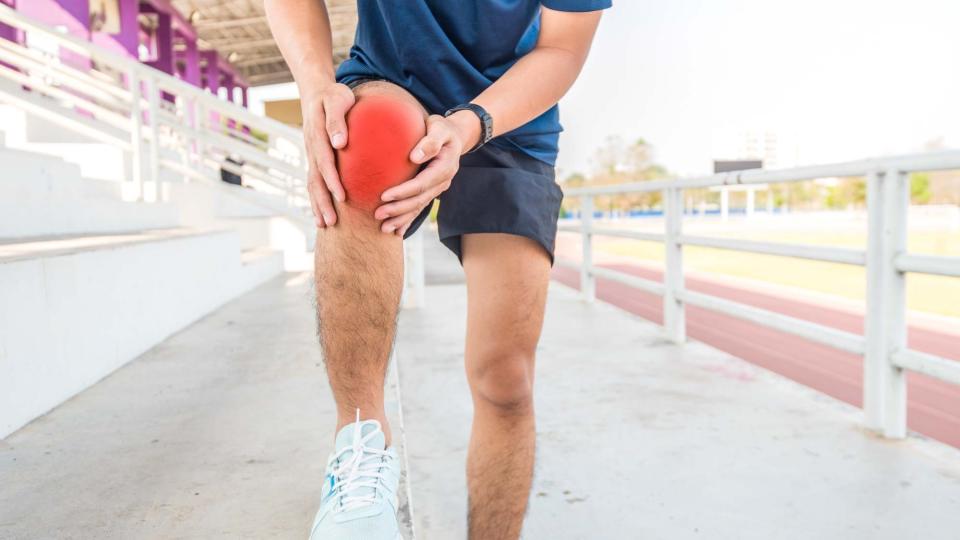 A runner holding his injured knee