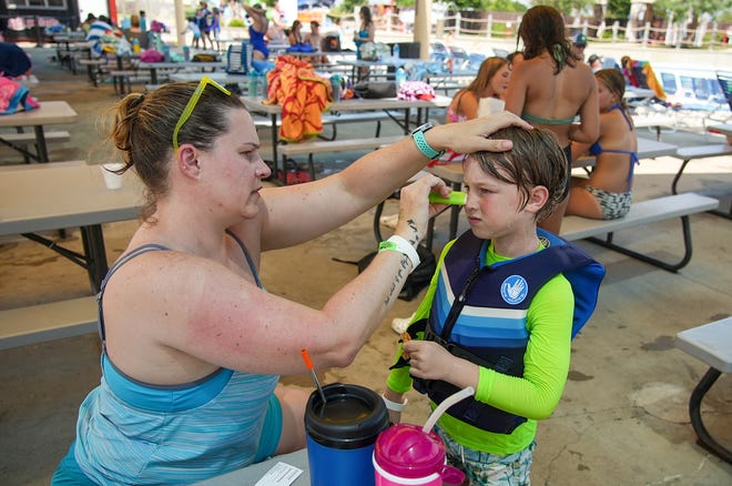 Mellissa Brown makes sure her son has sunscreen at Typhoon Texas. Some medications make people more likely to get sunburned.