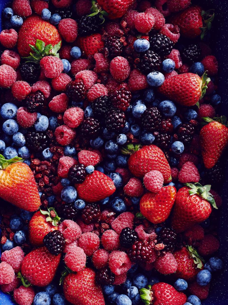 still life with an abundance of strawberries, blackberries, blueberries, raspberries and cranberries