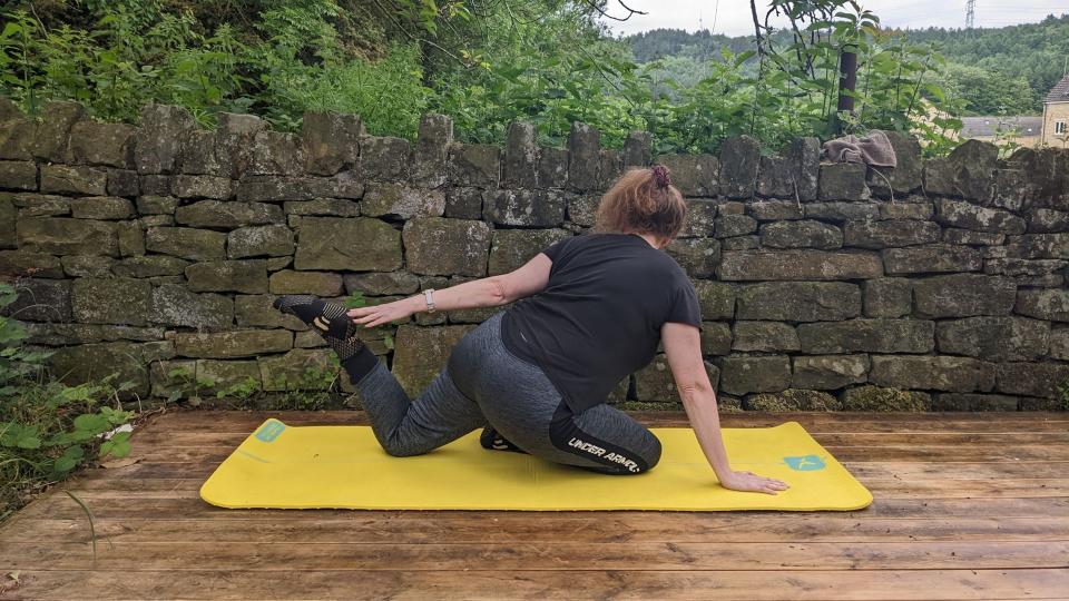 Samantha Priestley holds a yoga stretch, part of doing yoga every day, on her mat in the garden
