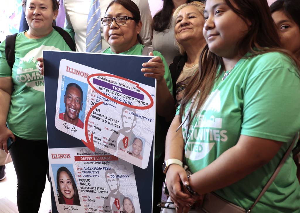 Supporters pose for photos with old, best and new Illinois state driver's licenses following the announcement of new legislation aimed at ending the stigma for immigrant drivers, during a press conference at the National Museum of Art Mexican in Chicago on June 21, 2023. The legislation would allow the state to issue standardized licenses to legally authorized immigrant drivers. 