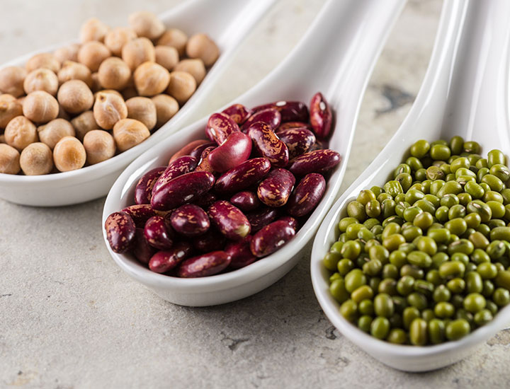 Beans and lentils on a white spoon