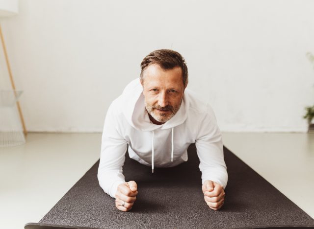 middle aged man doing planks, concept of exercises for men in his fifties