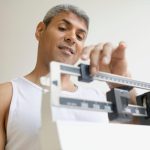 a man standing on a scale to lose weight