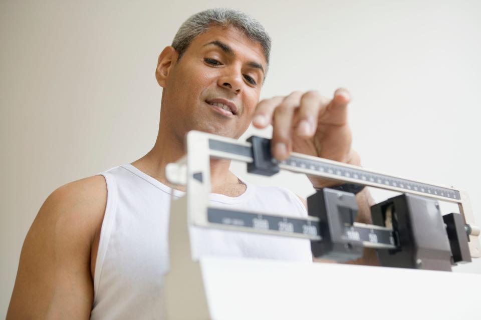 a man standing on a scale to lose weight