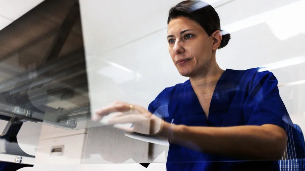 A medical professional checks a computer screen