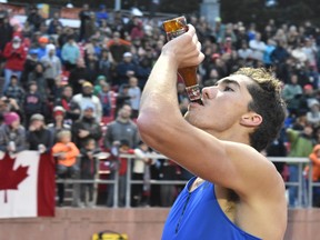 corey bellemore drinks a bottle of beer during a race
