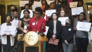 FIILE - Cassandra Welchlin, executive director of the Mississippi Black Women Roundtable, speaks during a news conference on groups pushing for lawmakers to extend postpartum Medicaid from 60 days to 12 months, Jan. 26, 2023, at the Mississippi State Capitol in Jackson. A Mississippi law that goes into effect on Saturday, July 1, 2023 authorizes one full year of postpartum Medicaid coverage. (AP Photo/Rogelio V. Solis, File)