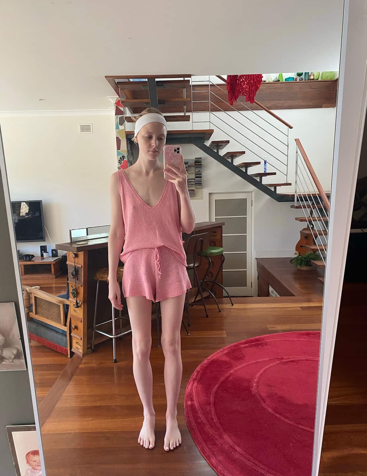 A young woman taking a picture of herself in the mirror