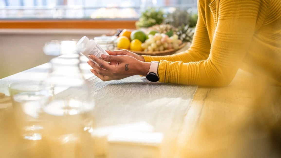A person holding a bottle of pills.